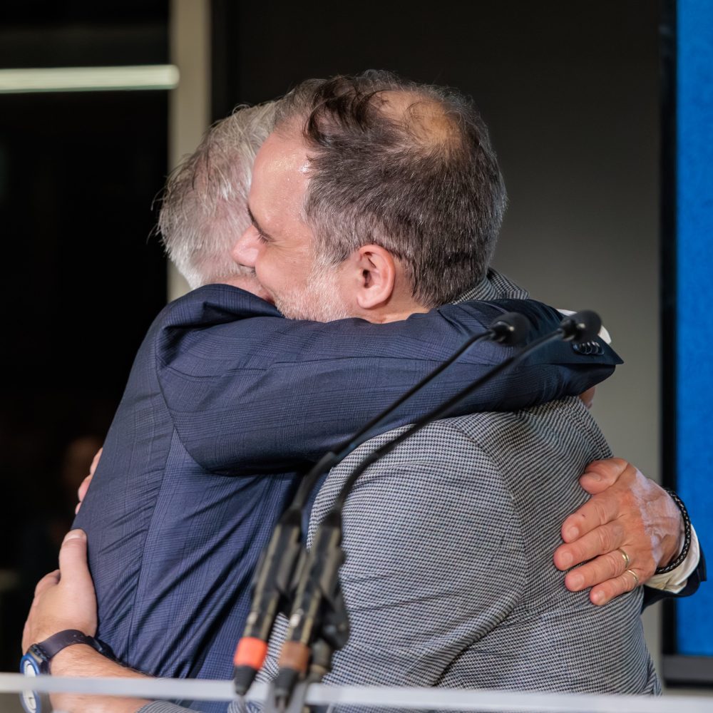 Un homme donne un câlin à un autre homme.
